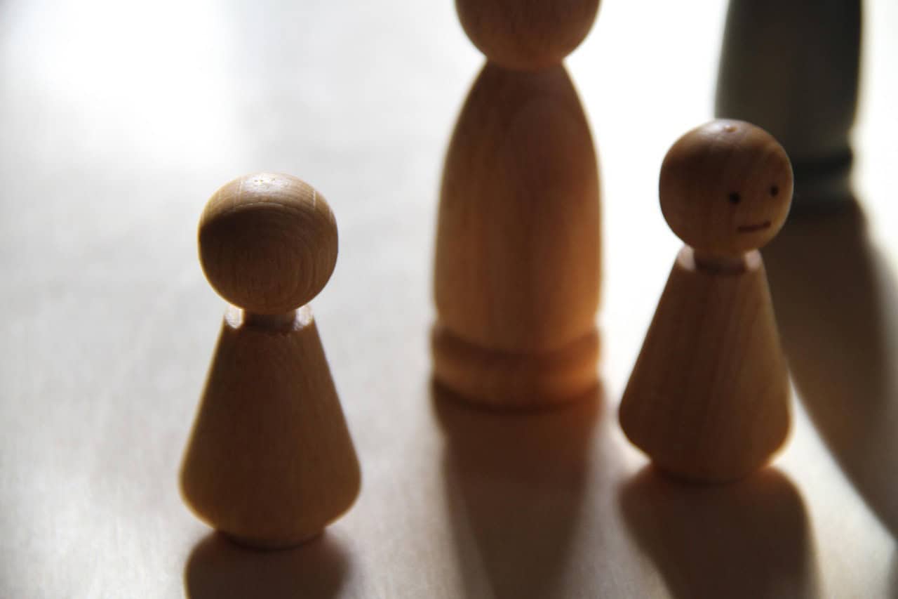 Wooden family figures representing inheritance and probate disputes among family members.